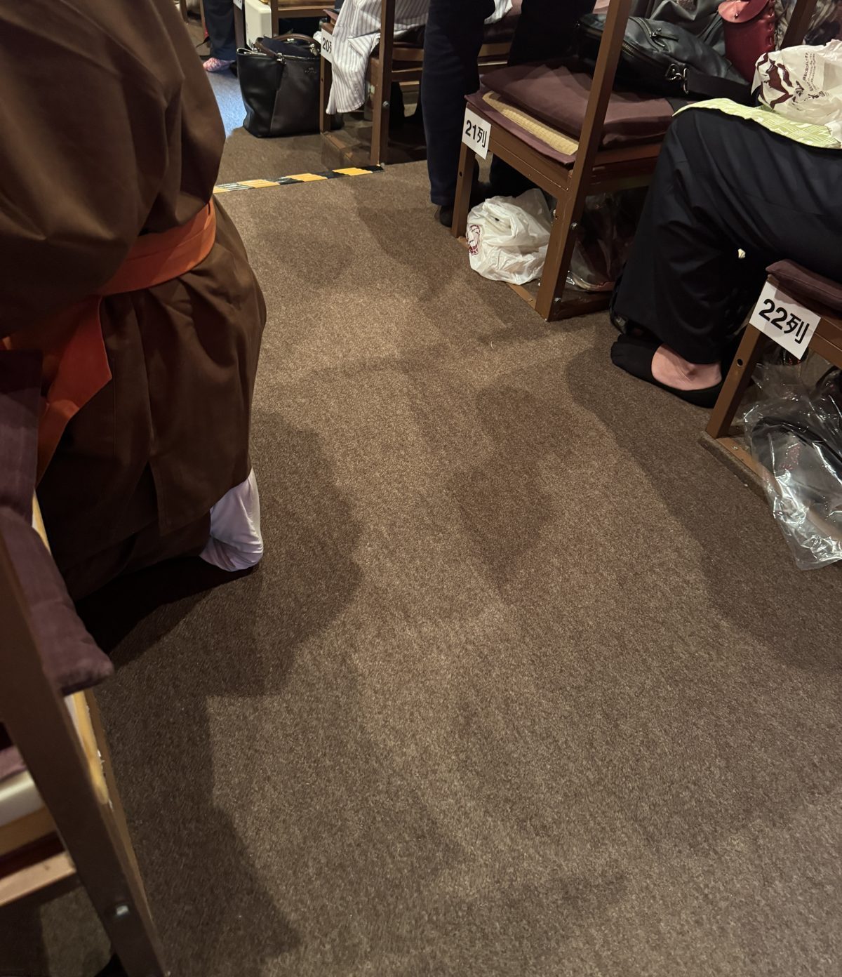 平成中村座の長椅子席の足元、座席の下に置かれた靴入れの透明袋とお茶子さん